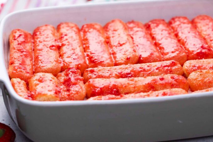 Assembling no bake strawberry tiramisu.