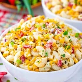 bowls of macaroni salad with diced veggies and bacon bits