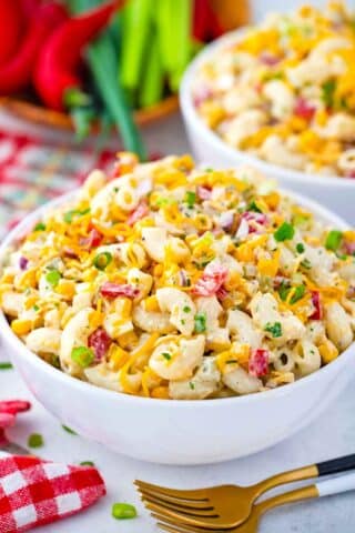 bowls of macaroni salad with diced veggies and bacon bits