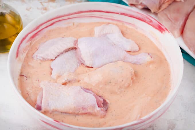 Marinating chicken pieces in buttermilk.