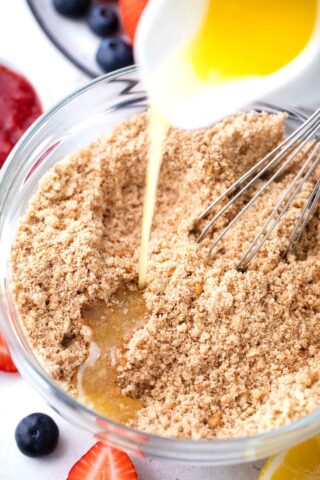 pouring batter into graham cracker crumbs