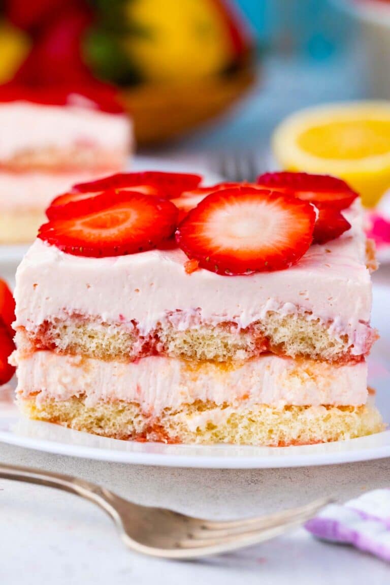 A slice of no bake strawberry tiramisu topped with fresh strawberries.