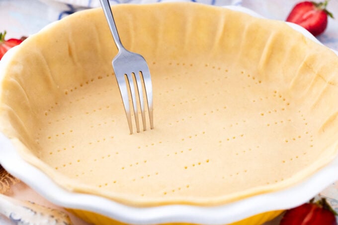 Poking pie crust.