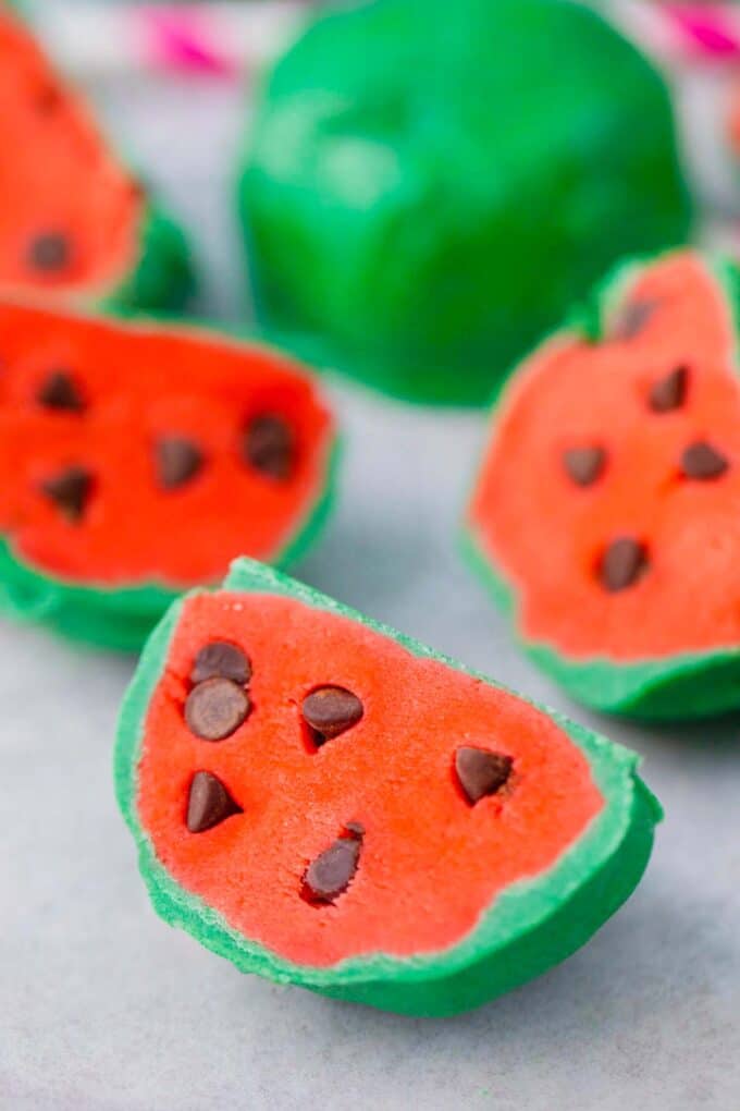 No bake watermelon truffles with green coating, pink center, and chocolate chips as seeds.