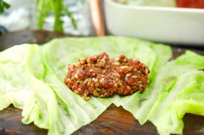 adding beef and rice mixture to a cabbage leaf