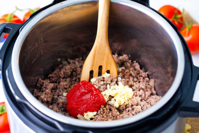 Searing ground beef with tomato paste and garlic in the instant pot.