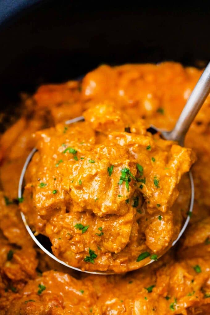 a ladle filled with creamy slow cooker butter chicken recipe