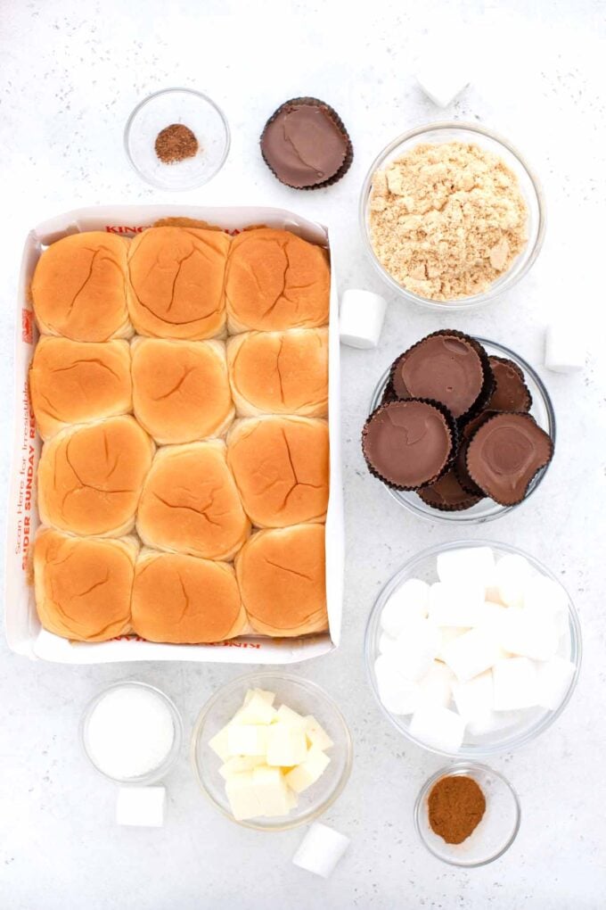 overhead shot of smores sliders ingredients in bowls and a pack of sweet Hawaiian rolls on a white surface