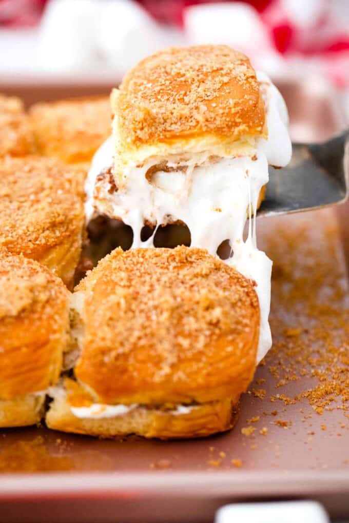 lifting a peanut butter cup smores slider with gooey marshmallow