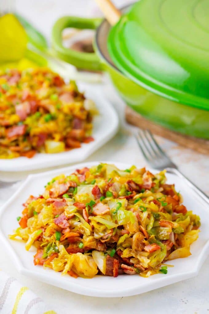 Two plates of bacon fried cabbage.