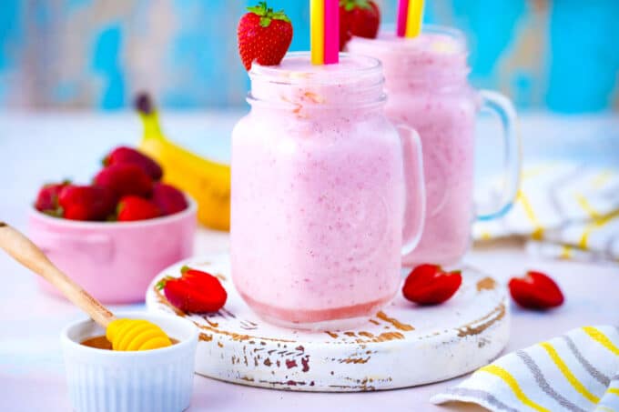 Strawberry banana smoothies garnished with fresh strawberries and banana slices.