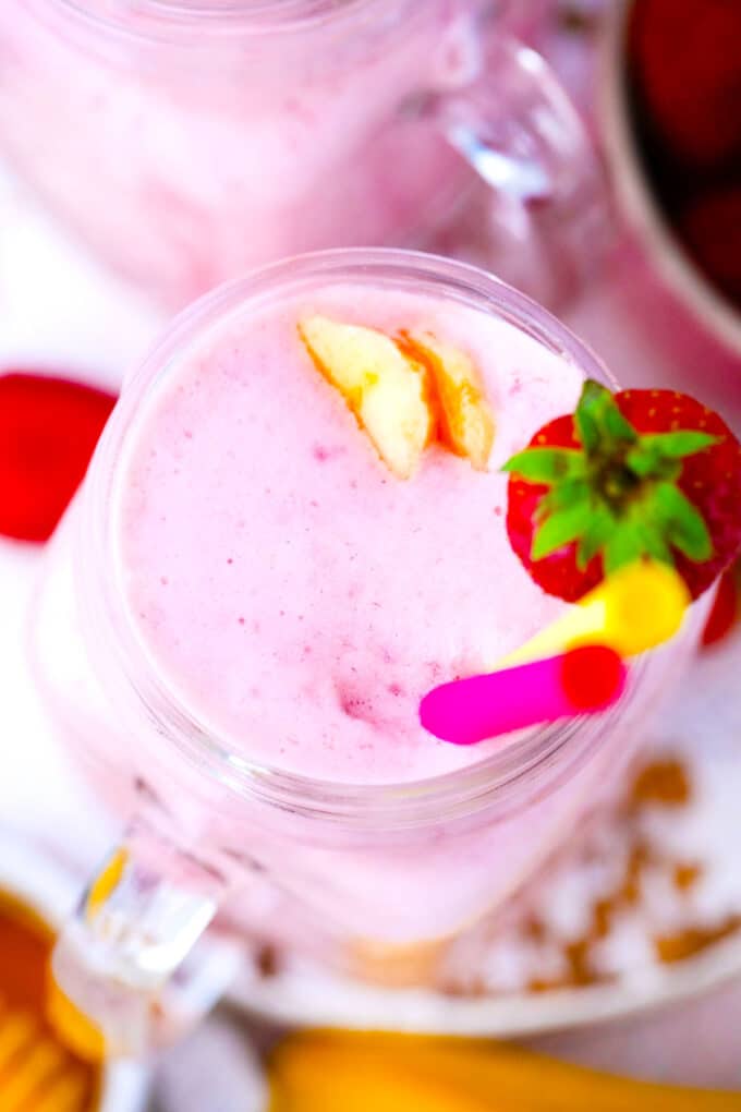 Overhead shot of strawberry banana smoothie garnished with fresh strawberries and banana slices.