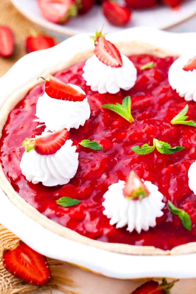 Strawberry cheesecake pie topped with whipped cream.