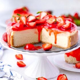 sliced strawberry cheesecake topped with strawberry sauce topping and fresh strawberries