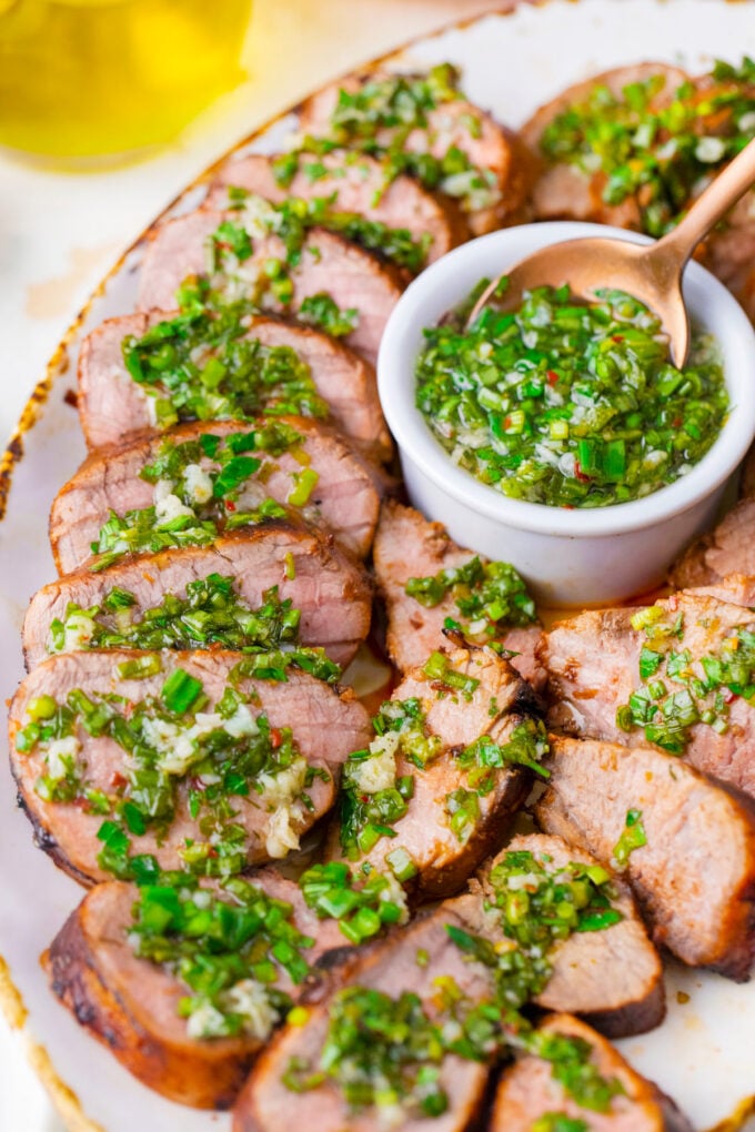 Tender grilled pork tenderloin served with olive oil garlic and herb sauce