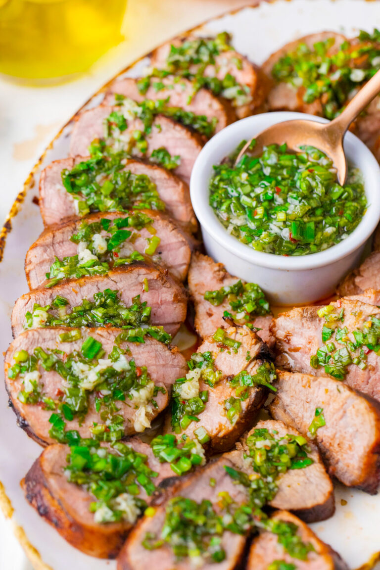 Tender grilled pork tenderloin served with olive oil garlic and herb sauce