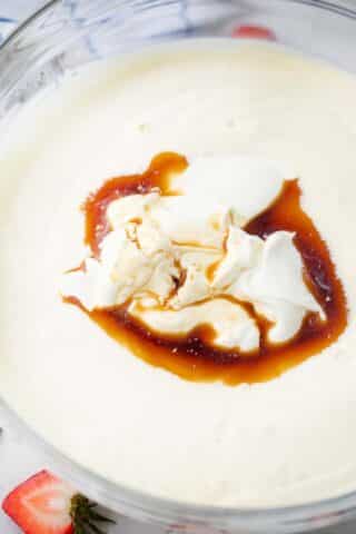 beating sour cream and vanilla extract into cream cheese mixture