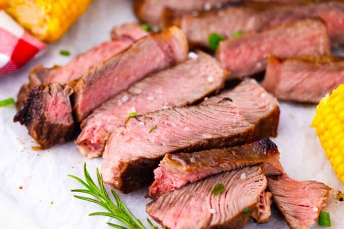 Sliced Asian style grilled steak topped with sea salt and served with corn on the cob.