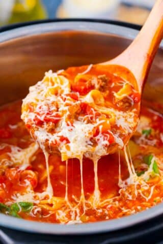 A ladle of homemade Instant Pot lasagna soup topped with cheese.