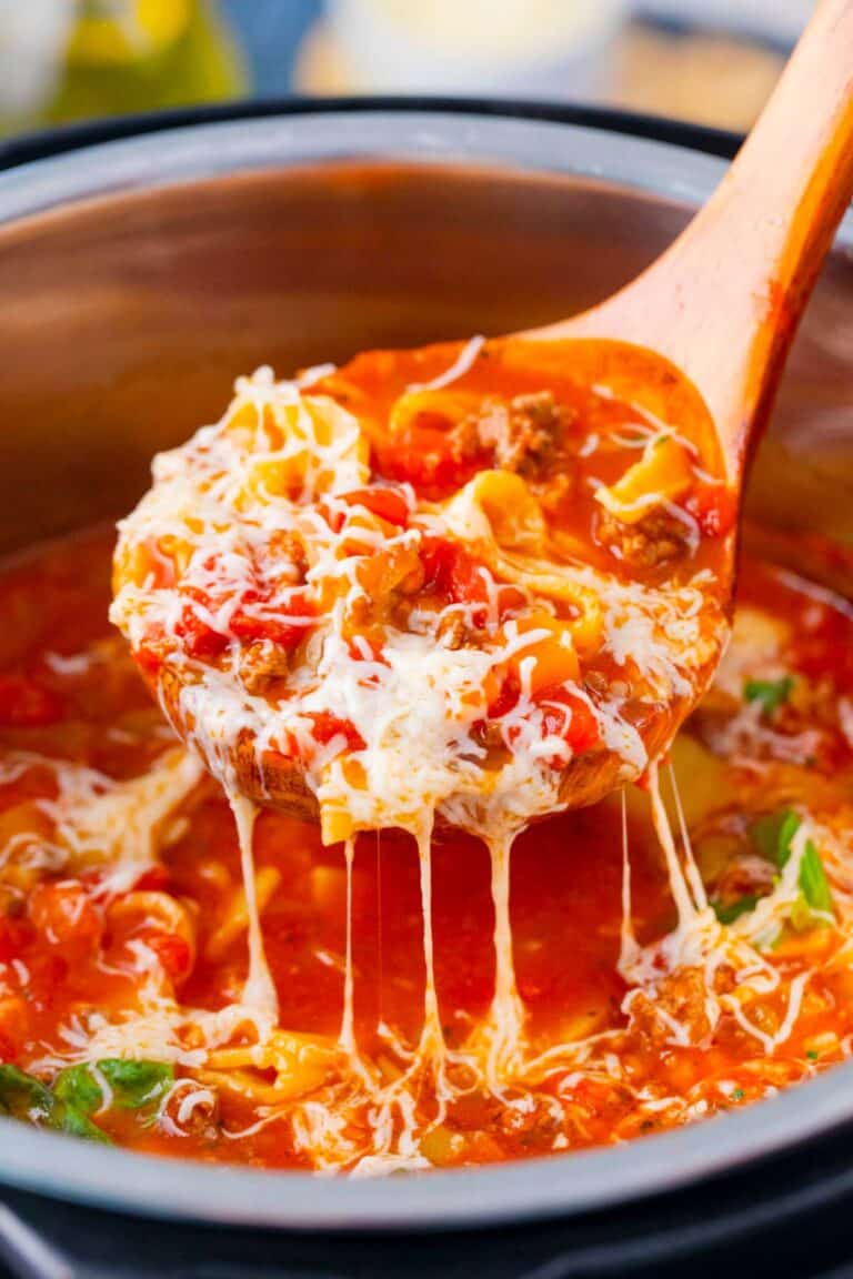 A ladle of homemade Instant Pot lasagna soup topped with cheese.
