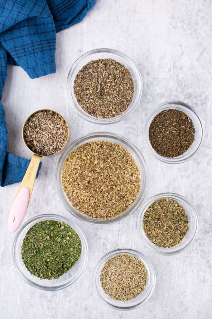 Homemade Italian seasoning blend ingredients in bowls on a table.