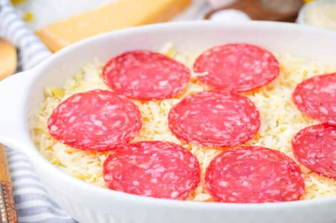 White pizza casserole topped with pepperoni slices right before baking it.