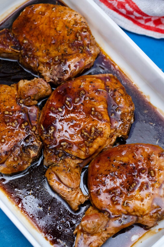 Baking pork chops covered in brown sugar sauce.