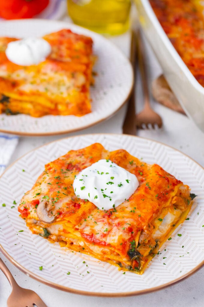 Sliced chicken spinach lasagna topped with ricotta.