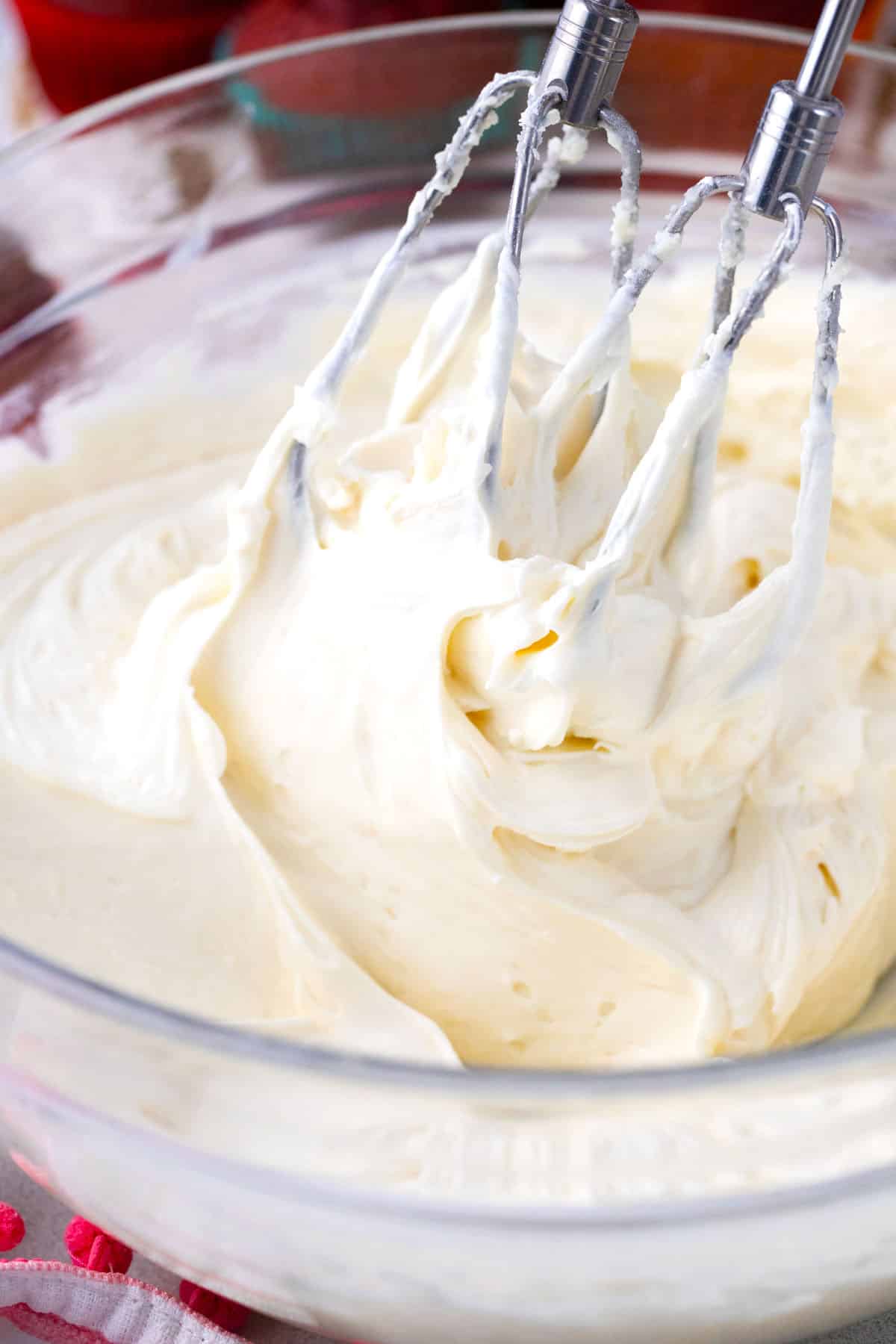 Beating cream cheese frosting in a bowl.