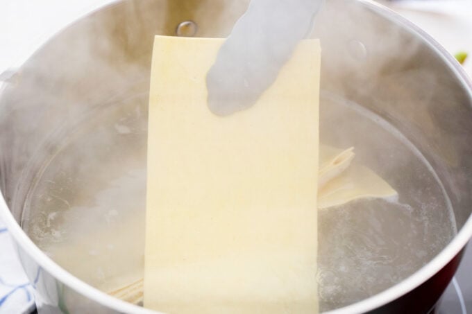 Boiling lasagna sheets.