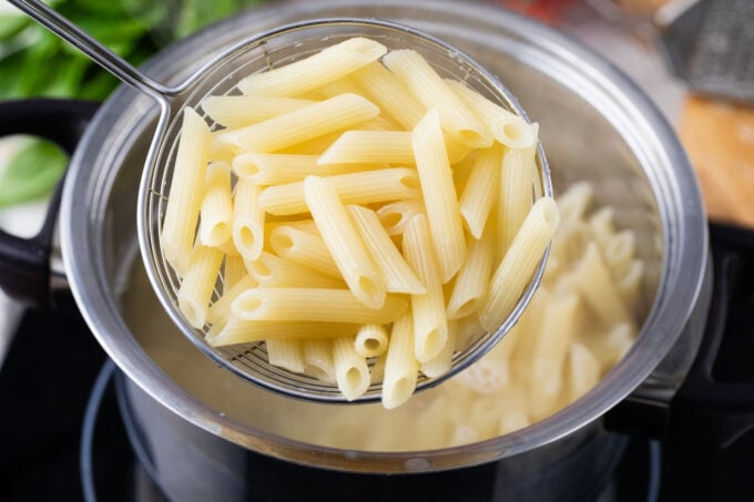 Boiled penne pasta in a colander.