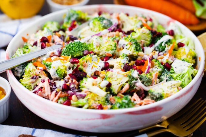 A bowl of broccoli salad with pomegranate seeds.