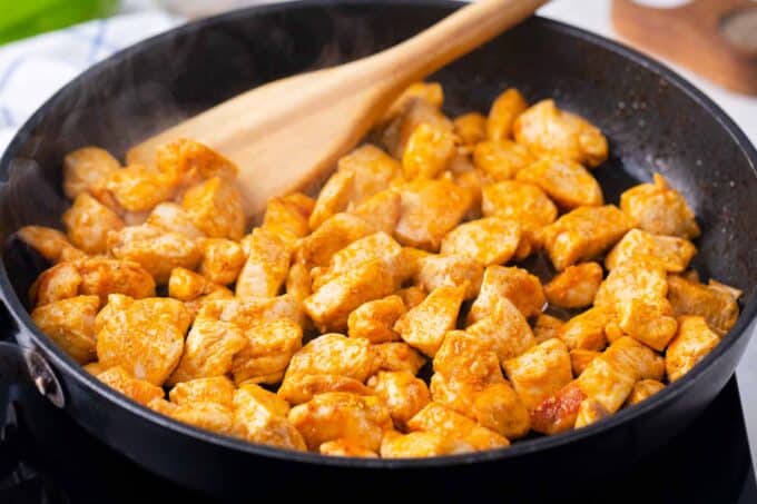 Cooking chicken pieces in a pan.