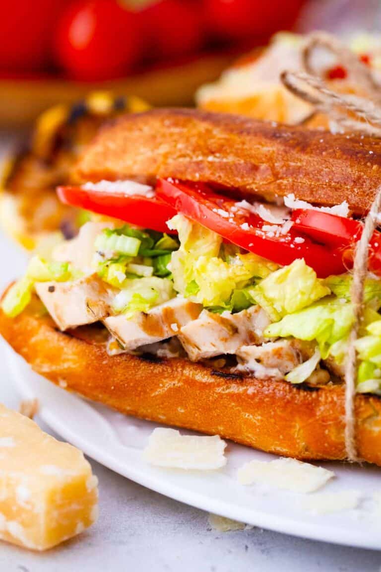 close shot of chicken caesar sandwich with sliced grilled chicken breast