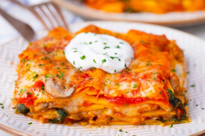 A slice of cheesy chicken spinach lasagna.