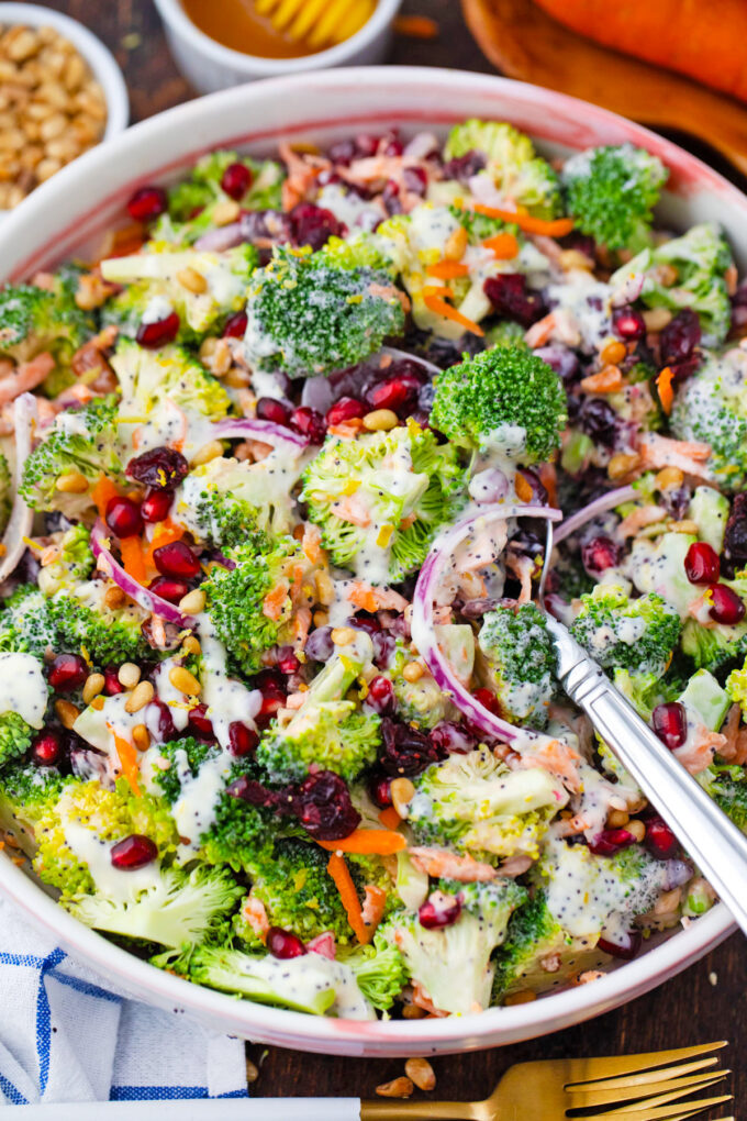 Broccoli salad with carrots, onion, and pomegranate seeds.