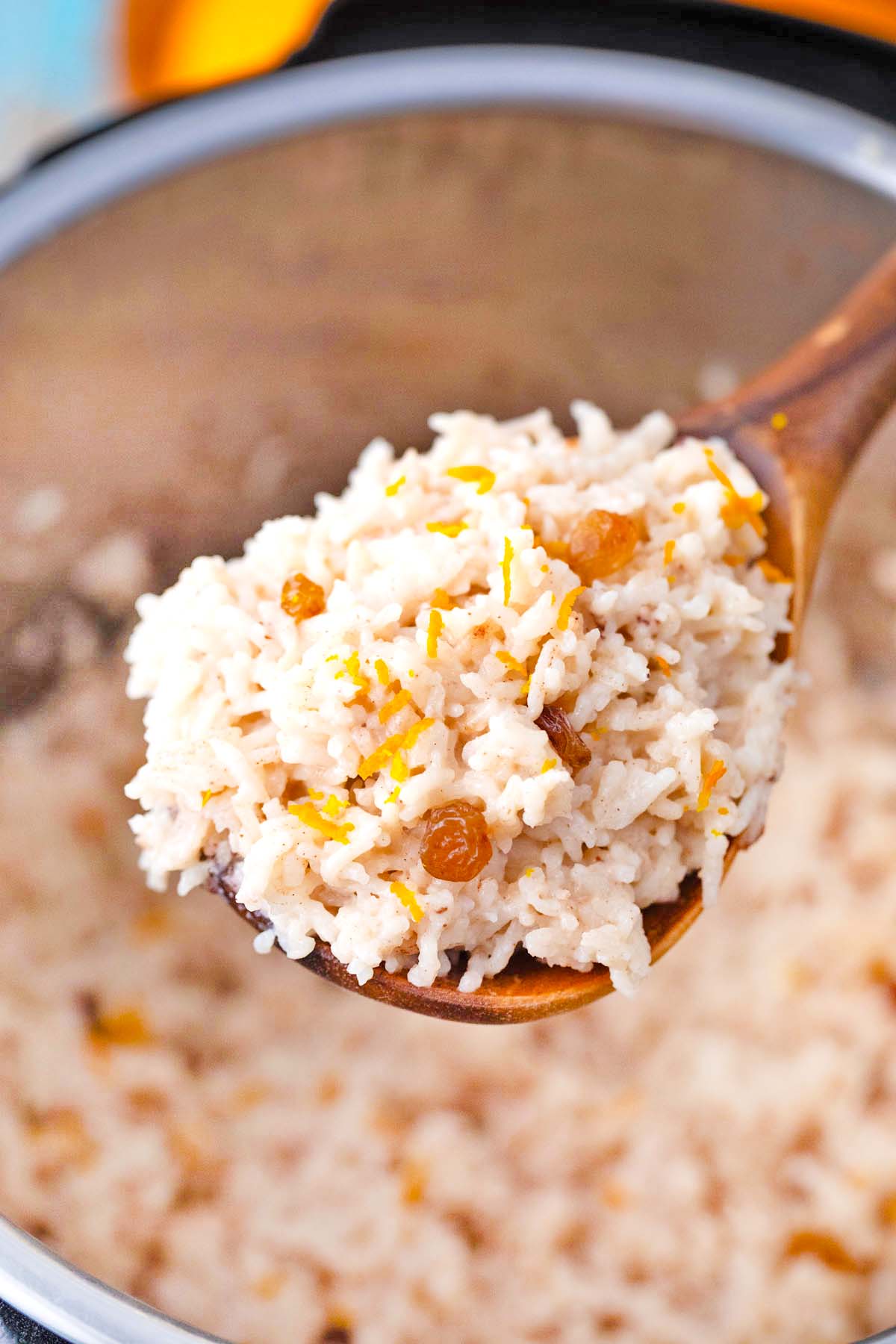 a large serving spoon of creamy instant pot rice pudding with raisins