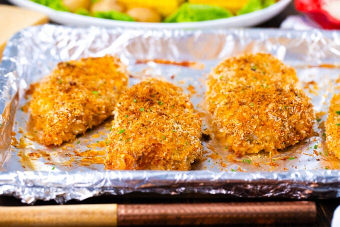 Crispy baked pork chops on a baking sheet.