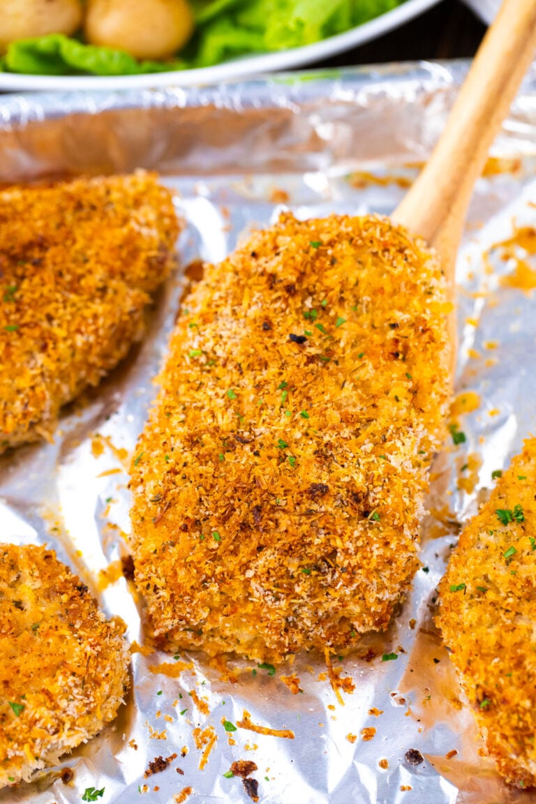 Lifting a crispy baked pork chop with a serving spatula.