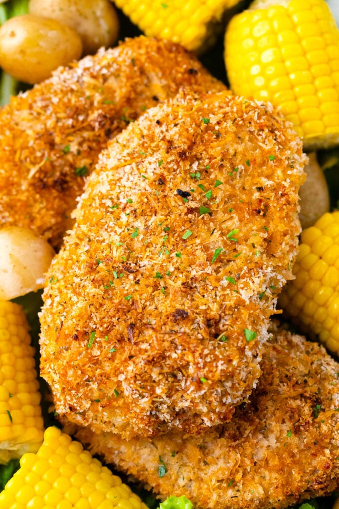 Crispy baked pork chops served with corn on the cob.