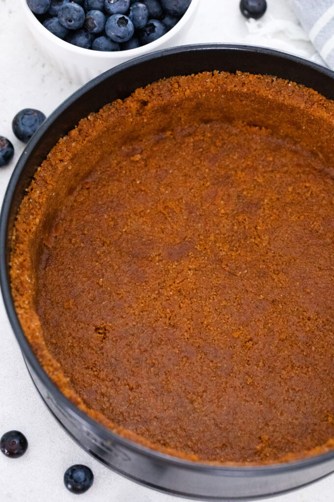 Biscoff cookie crust in a springform pan.