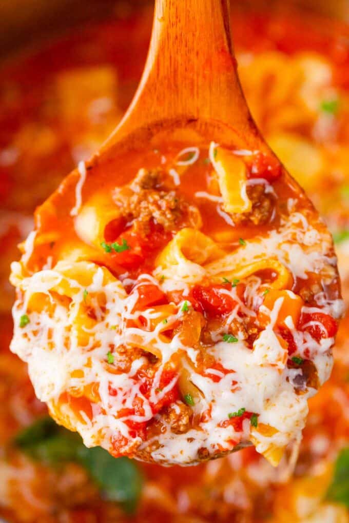 A ladle filled with cheesy Instant Pot lasagna soup.