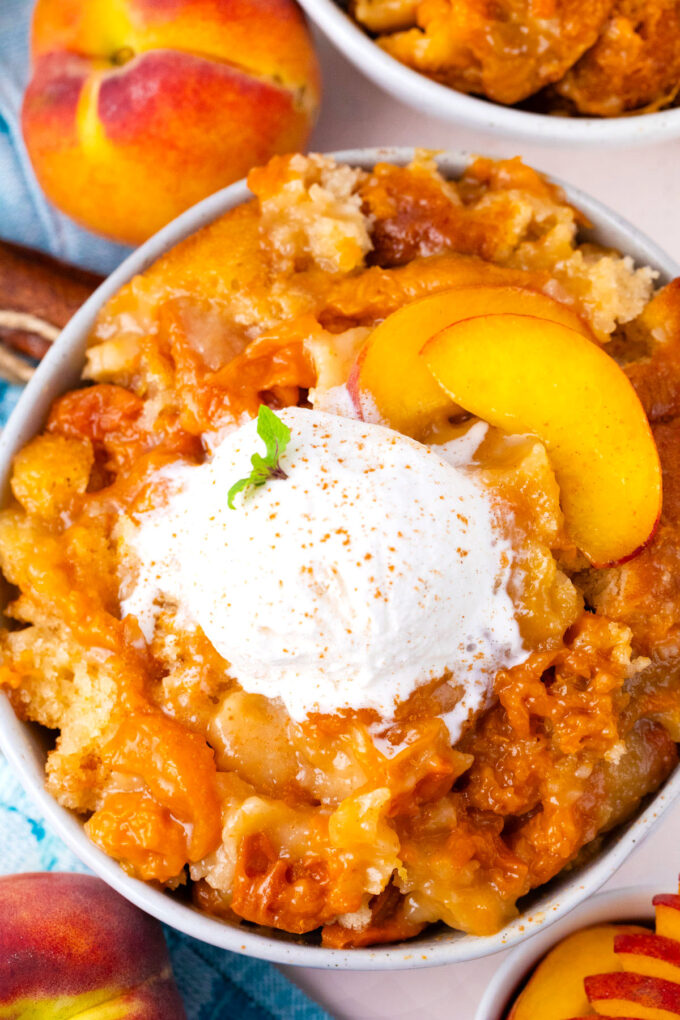 Overhead shot of homemade peach cobbler topped with ice cream.