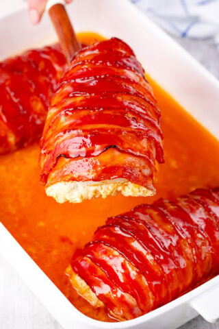 Very juicy and crispy bacon wrapped cream cheese stuffed chicken on a serving spatula.