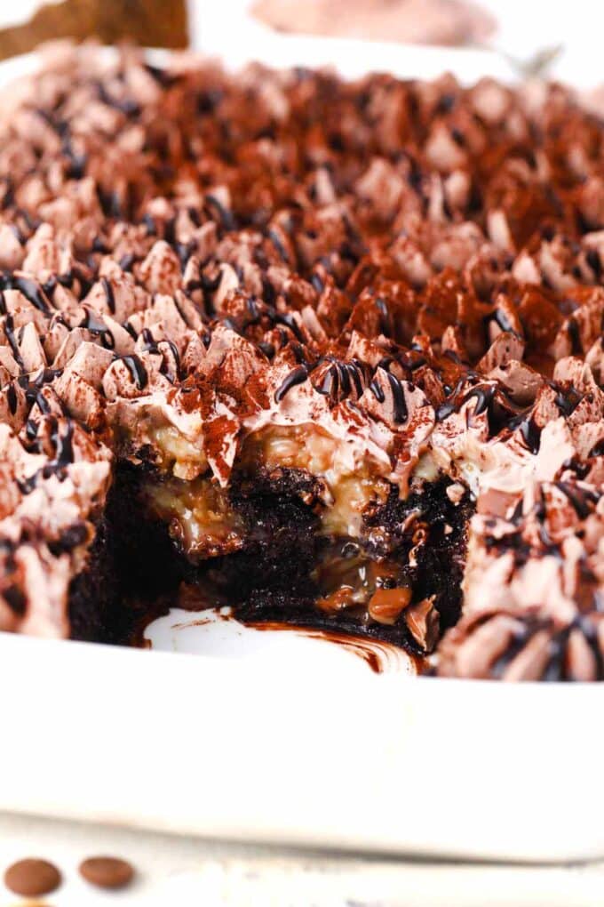 german chocolate poke cake topped with chocolate whipped cream