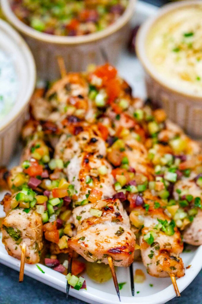 Grilled chicken souvlaki skewers topped with cucumber, tomato, olive relish.