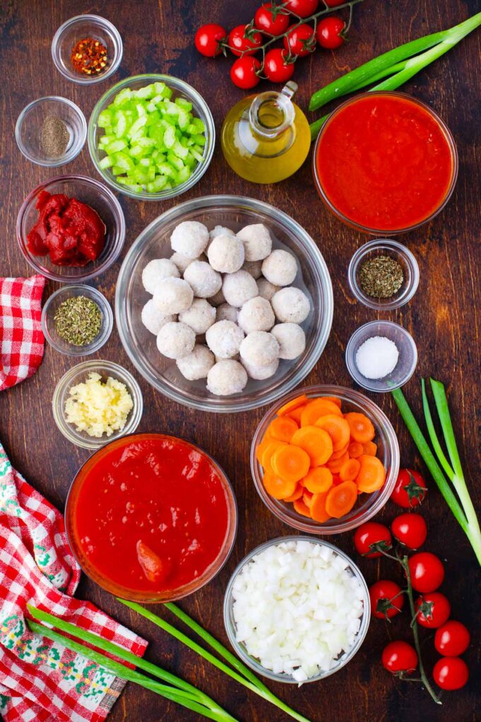 Instant Pot Italian meatball soup ingredients in bowls on a wooden surface.
