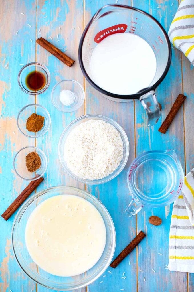 instant pot rice pudding ingredients in bowls on a wooden blue table