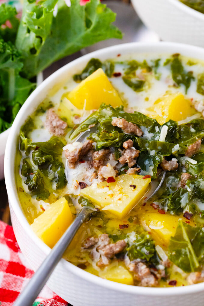 A spoonful of instant pot zuppa toscana with sausage, kale, and potatoes.