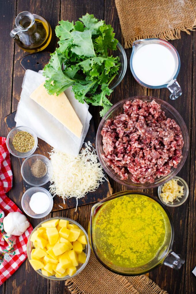 Overhead shot of instant pot zuppa toscana ingredients in bowls on a wooden table.